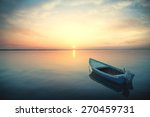 Canoe floating on the calm water under amazing sunset