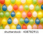 Colorful balloons tacked on yellow textile wall; Target items at funfair booth; Aim of throwing game
