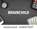 Small photo of BRAINCHILD - word (text) and money dollars on the table, phone magnifying glass (loupe) and calculator. Business concept, buying goods and products, paying for services (copy space).