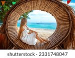Beach vacation influencer poses on tropical paradise beach with blue sea in the background. Summer holiday and travel concept.