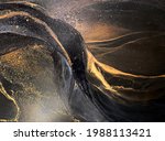 Abstract black art with gold — black background with beautiful smudges, stains and splashes made with alcohol ink. Gold fluid texture resembles space, night sky, stone, smoke, watercolor or aquarelle.