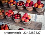 Small photo of Row of wooden baskets full of fresh picked plums and peaches on shelves display at roadside market stand in Santa Rosa, Destin, Florid, homegrown fruits summer harvest stall. Organic food local grow