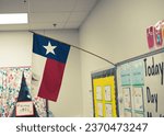 Small photo of Cute classroom bulletin board and proudly display of Texas flag in pre-kindergarten classroom, Dallas, USA, modern preschooler class furniture, well organized supply. American education background