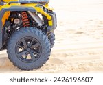 Small photo of Low pressure tire angled shoulder tread design ATV all-terrain vehicle improved grip, traction, front shock absorber shocker suspension of modern quad bike riding on white sand dunes, Mui Ne. Vietnam