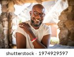 Portrait of a healthy black man living with HIV sitting on picnic table under covered area at a park