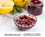 Small photo of Homemade quince jam in a glass jar on an old wooden background. Fresh quince fruits and leaves and quince jam. (Turkish name; ayva receli)