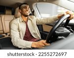  Portrait of happy african american man driving car with beige interior