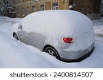 Small photo of Car covered with a huge pile of snow. Extreme weather conditions. Consequences of heavy snowfall