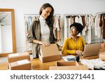 Small photo of Two happy business women working as a team in fulfilling orders for their online clothing store. Female entrepreneurs venturing into dropshipping as they expand their boutique with an ecommerce site.