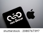 Small photo of NSO Group logo on smartphone placed on top of blurred Apple logo on Macbook. Concept for litigation between two companies after privacy breach. Stafford, United Kingdom, November 24, 2021.