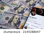 Small photo of Elon Musk's Twitter account page on the smartphone which is is placed on the pile of dollar banknotes. Twitter cash takeover concept. Stafford, United Kingdom, April 11, 2022