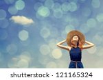 Redhead girl at spring blue sky background. Photo with bokeh at background.