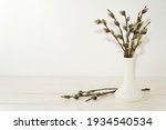 Happy Easter Day card with pussy willow tree in white vase. Branches Of The Pussy Willow on white wooden rustic background. Minimal Easter concept. Copy space for text.                      