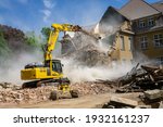 Small photo of Construction site digger yellow demolishing house for reconstruction