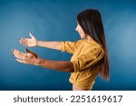 Small photo of Side view of cheerful woman isolated over blue background outstretching hands as if giving for free, offering to embrace, complacency and egoism concept. Satisfy longing, share excitement.