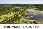 Aerial view of open water marsh and recreational trail through it. Midwestern landscape, wilderness from above. Daytime, summer