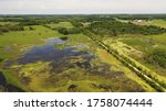 Aerial view of open water marsh and recreational trail through it. Midwestern landscape, wilderness from above. Daytime, summer