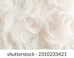 Small photo of Stylish wedding background beige ruffle bridal dresses. Background illustration of wedding decor. Gentle waves of silk fabric