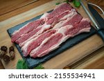 Small photo of Fresh Sliced brisket beef on black plate, Sliced brisket beef on wooden background.
