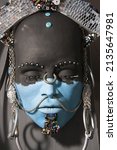 Small photo of Indigenous face sculpture. Close-up of statue, portrait of person with African features. Artwork with incorporation of recycled materials.