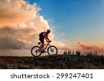 Biker riding on bicycle in mountains on sunset