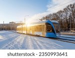 Small photo of Blue tram rushes through the city in winter reflection of the sun's light effect