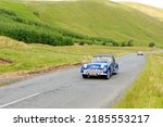 Small photo of Birkhill, Scotland - JUNE 25, 2022: 1960 Blue Triumph TR3 A Roadster sports car in a classic car rally en route towards the town of Moffat, Dumfries and Galloway