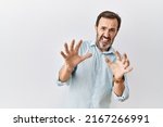 Middle age hispanic man with beard standing over isolated background afraid and terrified with fear expression stop gesture with hands, shouting in shock. panic concept. 