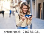 Young woman tourist smiling confident watching video on smartphone at street