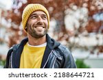 Small photo of Handsome hispanic man with beard smiling happy outdoors