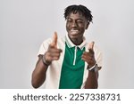 African man with dreadlocks standing over isolated background pointing fingers to camera with happy and funny face. good energy and vibes. 