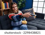 Young woman watching movie sitting on sofa at home