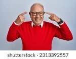 Small photo of Senior man with grey hair standing over isolated background smiling pointing to head with both hands finger, great idea or thought, good memory