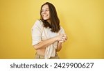 Small photo of Radiant young hispanic woman stands confidently, her captivating smile accentuates her beauty, against an isolated yellow background, showcasing her casual fashion and exuberant lifestyle.