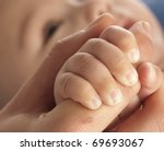 adult holding a baby hand, extreme closeup photo