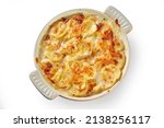 Small photo of Top view of palatable gratin made of potatoes and cheese in casserole and served on white isolated background
