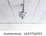 Small photo of A white overhead projector on ceiling in a conference room/modern classroom (color toned image)