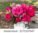 Small photo of A vase arrangement of pink roses. Rosa 'Simply Samantha' (Korsamasi).