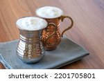 Small photo of Buttermilk, Ayran - Traditional Turkish yoghurt drink with foam in a copper metal cup. Sparkling buttermilk in two copper glasses.