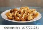 Small photo of Pure butter mushrooms lie on a porcelain flat plate and are ready for further processing. Edible pale yellow mushrooms with shiny caps are a godsend for gourmets. Glass background with reflection.