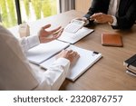 Small photo of Female real estate agent in suit showing numbers and calculating house, property price on calculator for buyer or client while sitting at desk to discuss and negotiate about contract at office.