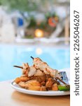 Small photo of Chicken souvlaki and potatoes at a plate at a beach bar annex restaurant on the Greek island Karpathos