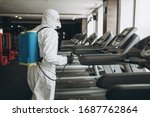 Small photo of Cleaning and Disinfection in crowded places amid the coronavirus epidemic Gym cleaning and disinfection Infection prevention and control of epidemic. Protective suit and mask and spray bag