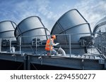 Small photo of Engineer under checking the industry cooling tower air conditioner is water cooling tower air chiller HVAC of large industrial building to control air system.