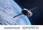 Small photo of Russian spaceship in space. Cargo spacecraft flight in outer space to space station. Earth orbit with stars. Elements of this image furnished by NASA