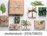 Small photo of Craft gift boxes on a white background, thuja branches. Concept for Christmas holidays and DIY eco gifts. Postcard, layout. Boxing Day.