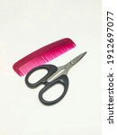 Small photo of A small red comb and small black scissors, these two tools, when combined, will definitely make your hair look cooler and tidier.