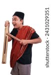 Small photo of Indonesian men wear capp or peci and sarongs while holding kentongan to wake people up for sahur. Asian man hits a gong or kentongan to wake people up for suhoor or sahur.