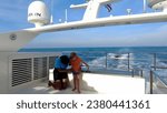 Small photo of Phuket, Thailand, 30,September, 2023: Stewardess on a yacht and a boy, boy kisses a stewardess on a yacht, yachting team and guests