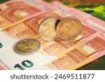 2 euro coins on euro banknotes. ...